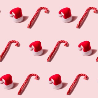 Trendy Christmas seamless texture with Santa Claus hat and candy cane. Modern christmas design