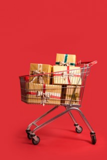 Shopping cart with Christmas gift boxes on red background
