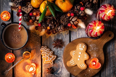 Christmas homemade gingerbread cookies, hot chocolate and candles on wooden table
