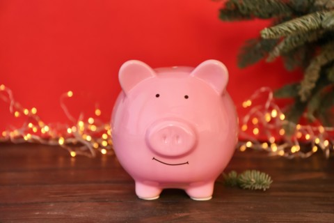 Piggy bank and blurred Christmas lights on background