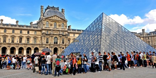Tourists queue before the Pyranid of Louvre museum, Paris, France