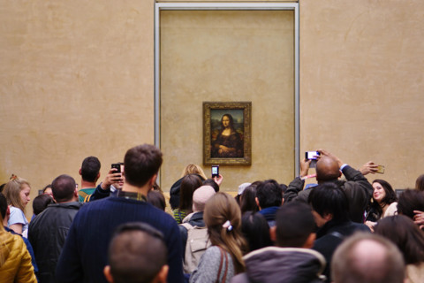 Visitors take selfie pictures on their phones in front of the Mona Lisa (La Joconde) painting by Leonardo da Vinci in the Louvre