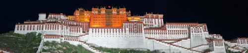 Panorama of Potala Palace at night (Lhasa, Tibet). Black sky, the palace is illuminated. On top of the home of the Dalai Lama waves the Chinese flag.