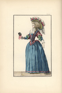 Woman in a ball gown, with chapeau topped with a pouf decorated with ribbons and laurel leaves, fichu, corset in English taffeta, and blue taffeta petticoat. In her hand is a black ball mask with pink...