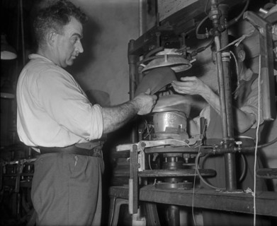Flat cap being pressed on to a mould at the Denham and Hargreaves factory, Atherstone. Circa 1960