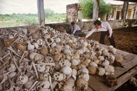Haing Ngor, with a pile of skulls and bones of executed victims of the Pol Pot regime,