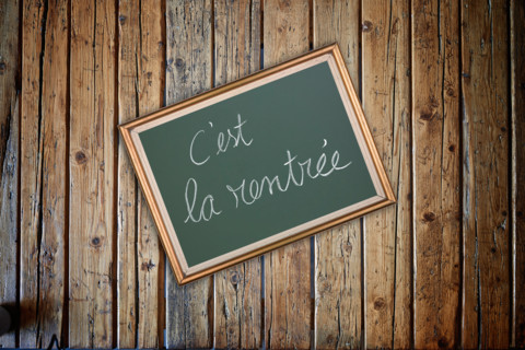 Wooden textured table from above and back to school concept in french