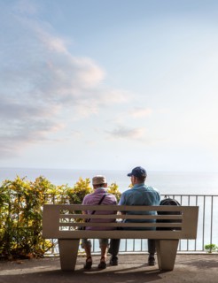 Rear view of senior couple sitting and look at the endless horizon
