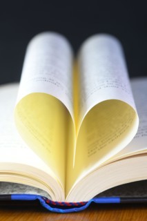 vertical heart shaped book pages showing spine ,selective focus on a black background concept of the love of reading