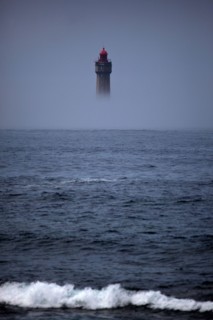 The dramatic La Jument lighthouse, shrounded in summer fog, off the coast of the Ile d'Ouessant, Brittany. The iconic 47-metre high lighthouse was bui