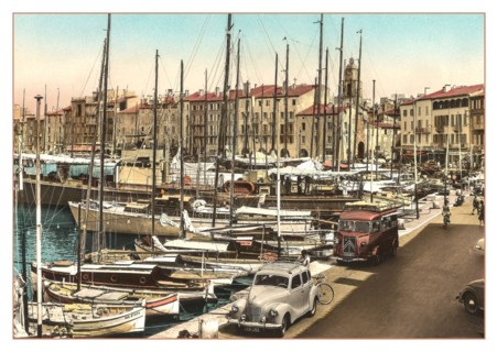 ST.TROPEZ Vintage 1950’s 1960's View of the harbour with fishing and sailing boats moored with French Citroen Van and Peugeot Motorcar parked, cafes and restaurants behind. Côte d’Azur South of France...