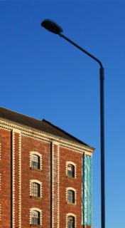 A classic street lantern embraces a stone building with bricks, against the background of the blue sky, Greenock, Scotland