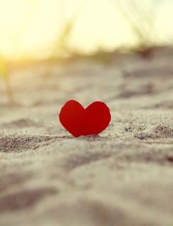 Toned Photo of the Red Heart in the Sand at the Evening Beach