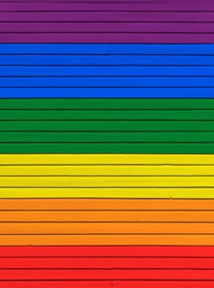 Wood board wall painted in rainbow flag colors. Abstract textured background. Gay pride and LGBT movement flag concept.