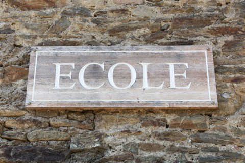 School signboard on a wall called ecole in French language