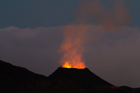 Ile de la reunion island Piton de la fournaise volcano eruption with lava flow and steam at night