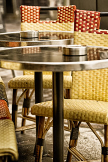 Paris sidewalk cafe classic bistro chairs and tables. Close up detail and vintage color.