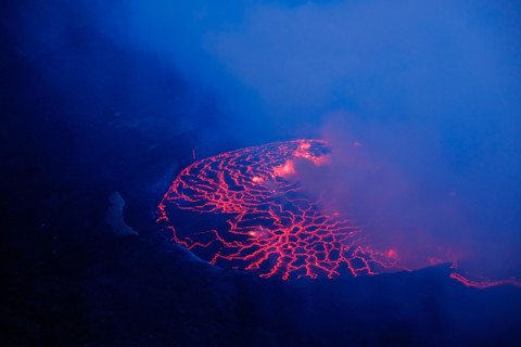 Lava and steam in crater of Nyiragongo volcano in Virunga National Park in Democratic Republic of Congo, Africa. Picture taken during dusk with blue c