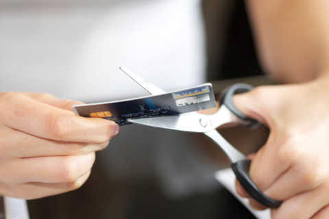 hands of female cutting a bank card in two/half