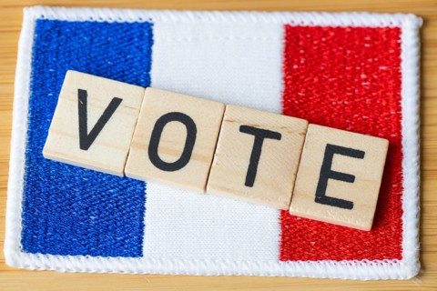 Voting in France. The flag of France and wooden blocks with the word Vote