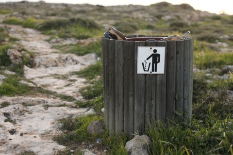 wooden trash or litter bin with for bottle, beer can and organic waste visibile showing pollution in coastal areas near the sea