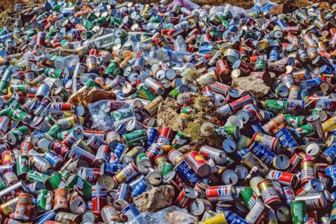 Archival shot of drinks cand discarded on a beach in the Mediteranean