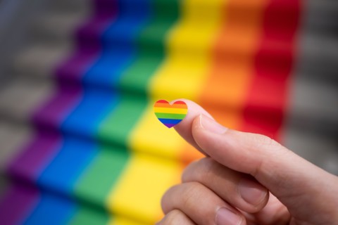 Heart shaped rainbow sticker in a hand for pride month celebration