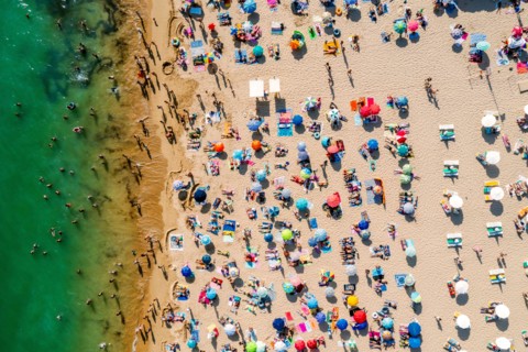 Drone shot of many people enjoying the beach and the ocean - vacation pattern. Rocha Beach in Portimao, Portugal