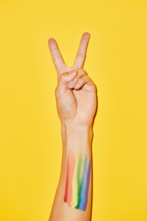 Vibrant shot of arm with rainbow flag tattoo and V symbol for pride month LGBTQ