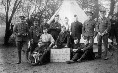 Aldershot, Hampshire. 1914 – British army soldiers of the Regimental Barber Shop, ‘F’ Company, Royal Army Medical Corps at Redan Hill Fort, Aldershot in 1914. The men are posing with their dog mascot ...