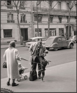Paris 1965 reportage moment lifestyle fashion street reportage. Citroen Deaux Chevaux passing in background Van de Poll [Street life in Paris] Man playing and feeding the dog of a passer-by 1965  Fran...