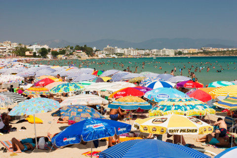 Overcrowded beach covered with sun umbrellas - Didim Altinkum, Turkey