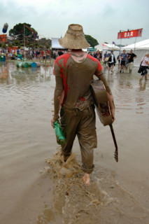 A musician walks through the flood water at the Glastonbury festival
