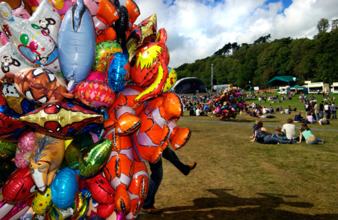 Balloon seller and festival goers at Bestival. Isle of Wight. UK
