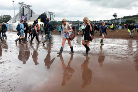 Festival reverlers struggle through the mud at the 2014 Glastonbury Festival.