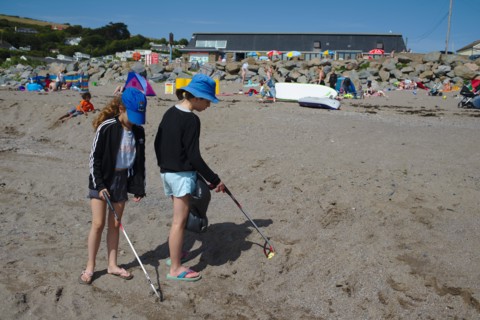 Beach clean up children help by volunteering to do five minutes of litter picking at Chalisborough. Devon UK
