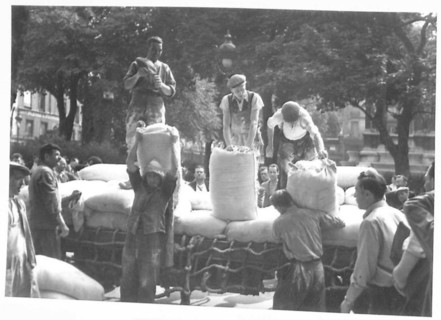 British Army personnel unload sacks of flour at Les Halles market in Paris, providing food supplies during World War II under the 21st Army Group.