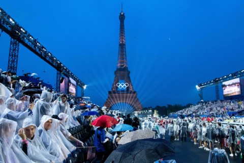 Symbolbild / Themenfoto Eiffelturm mit Beleuchtung und olympischen Ringen, davor Zuschauer am Trocadero im Regen mit Schirm und Regenponcho im Regen, FRA, Olympische Spiele Paris 2024, Eroeffnungsfeie...