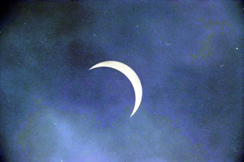 Eclipse in Northern France, 10-08-1999 Whizgle News, Dutch Desk, The Netherlands, 1950-2000 A delicate crescent moon glimmers softly against a serene blue sky, evoking a sense of calm and wonder.