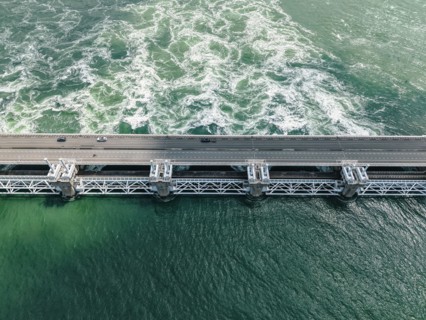 Oosterscheldekering, Delta Works sea barrier from above. Cars driving on the highway, water churning below. Engineering success, safety concept