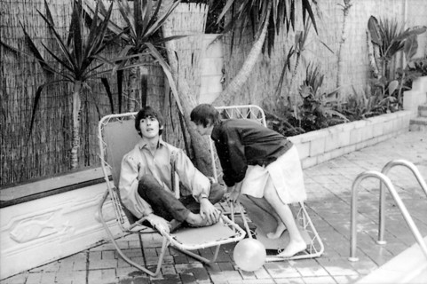 Beatles files 1964 George Harrison Ringo relax by their swimming pool in Bel Air California during their first American tour August 1964