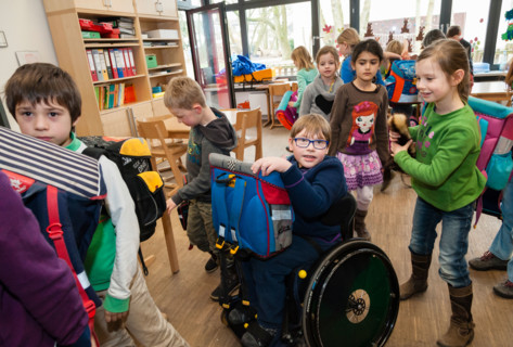 Non-disabled and disabled students (in this case a boy in a wheel chair) learn together in the same class in a primary school.