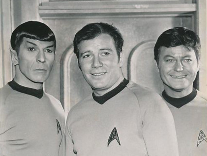 A cropped image from the 1969 'Star Trek' series featuring Leonard Nimoy, William Shatner, and De Forest Kelley as Spock, Captain Kirk, and Dr. McCoy.