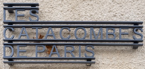 Paris, France - 8 Nov 24: Close-up of metal lettering reading "Les Catacombes de Paris" mounted on a stone facade in Paris, Île-de-France, France.