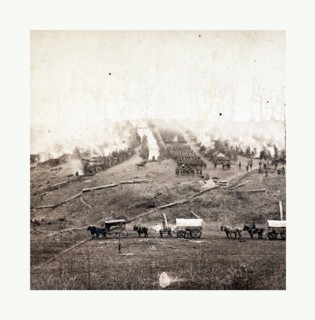 American Civil War: Three horse-drawn covered wagons in the foreground. Soldiers marching in