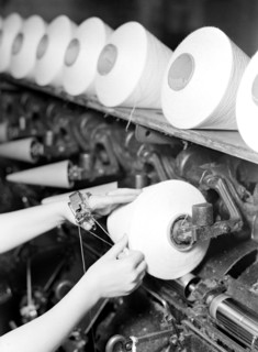 High Point, North Carolina - Textiles. Pickett Yarn Mill. Winder operator - close-up of hands,