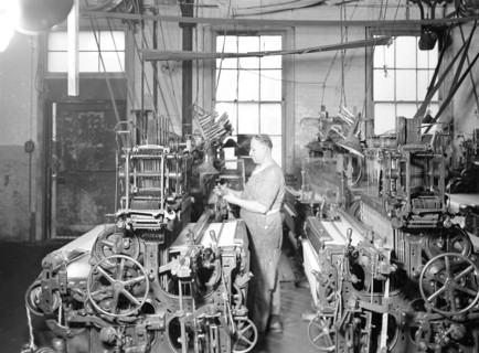 Paterson, New Jersey - Textiles. Weaver operating four-loom system. He is shown removing a used-up