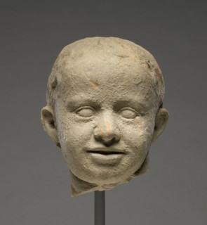 Head of a Child; Tarentum, Taras, South Italy; 300 - 200 B.C; Terracotta with clay slip; 13.5 × 11.5 cm, 5 5,16 × 4 1,2 in