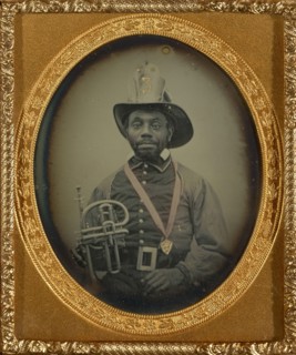 Fireman in Uniform Holding a Brass Instrument; American; 1855 - 1856; Daguerreotype, hand-colored; 6 x 4.9 cm