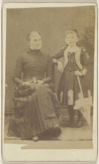 Mother sitting with a book in her lap, girl standing with an umbrella; American; about 1870; Albumen silver print